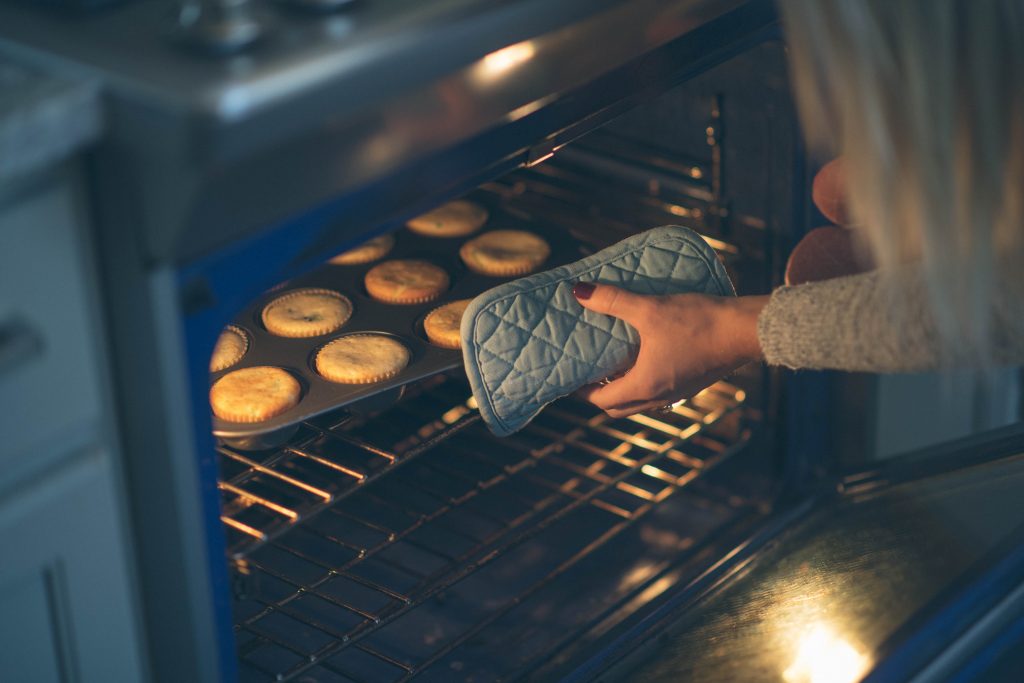 close up of muffins being pulled out of the oven