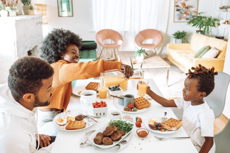 Mom, Dad and child sitting at a table eating breakfast - light colors, white dining room