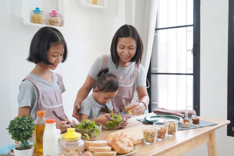 Mother and daughter cooking in the kitchen at home, happy family asian concept