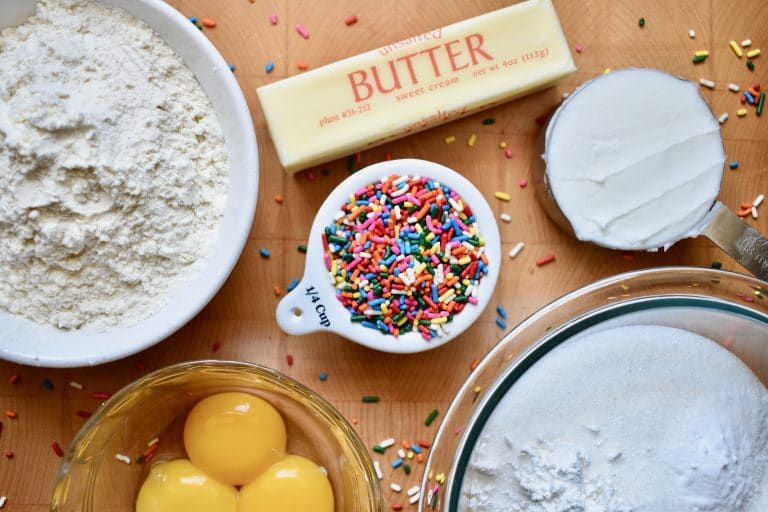 overhead shot of flour, butter, eggs and sprinkles. Ingredients needed for cookies