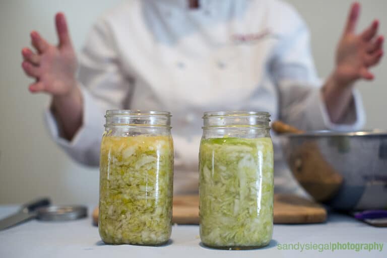 two jars of sauerkraut on a counter in front of a person