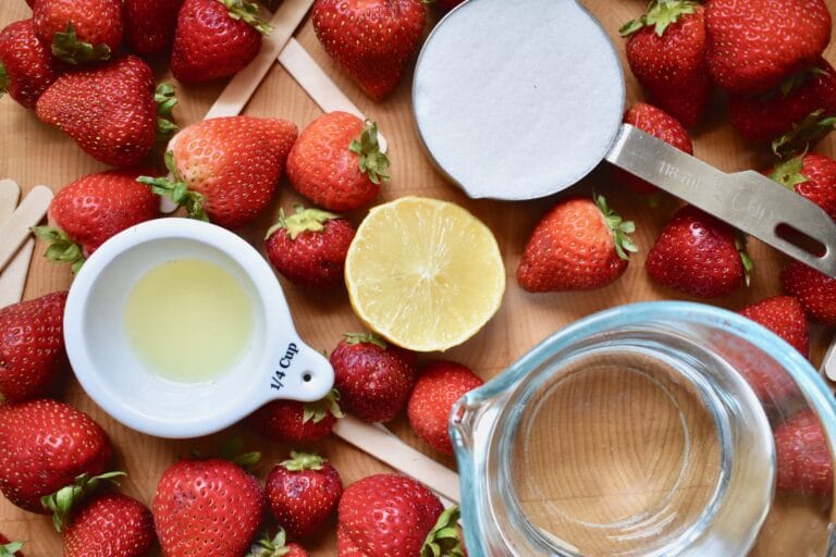 overhead shot of strawberries, lemons and sugar