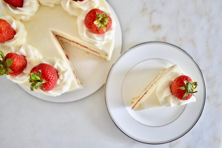 overhead shot of white cake with buttercream and strawberries